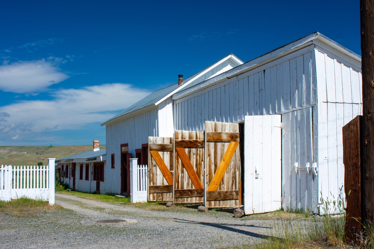 Bunkhouse Row Low, white buildings along a gravel drive.
