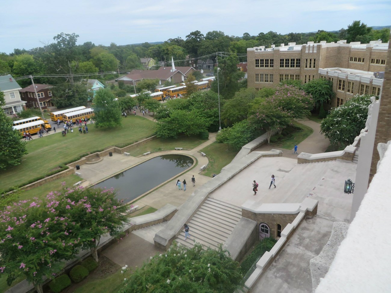 Overhead view of Central High School landscape, showing houses across the street, trees and reflecting pool, and broad staircase.