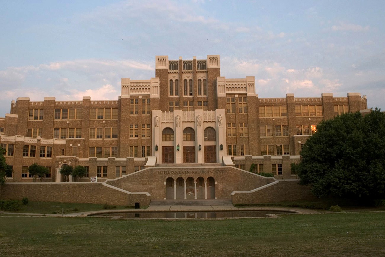 A staircase leads to an elaborate facade of the symmetrical Central High School, in the Neo-Gothic Revival and Art Deco style