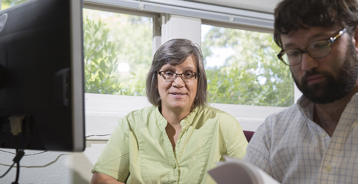 Cari Goetcheus works with a student at a computer