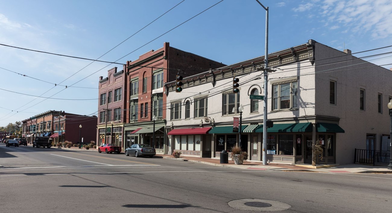 View down a block of the West Third Street Historic District, where 2 and 3-story brick buildings line a wide street