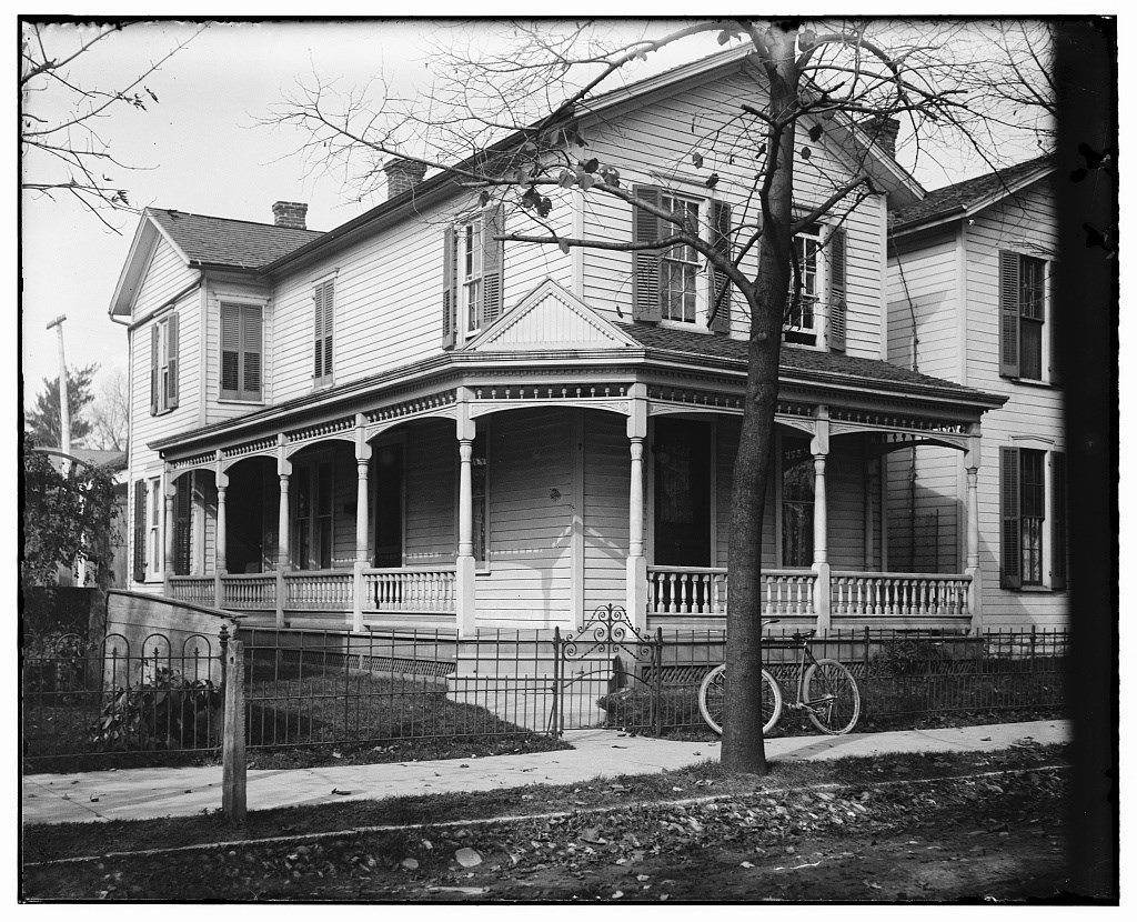 Front view of 7 Hawthorn Street, the Wright home, with bare trees and a bicycle resting by the right gate of the front fence, about 1900