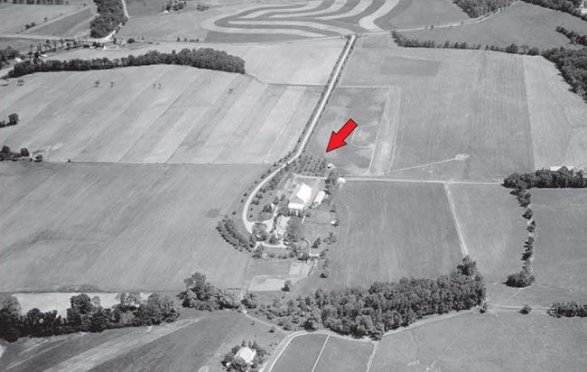 Eisenhower Farm aerial, 1964 An aerial view of a farm, with fields surrounding a barn, house, tree-lined driveways, and clusters of vegetation.