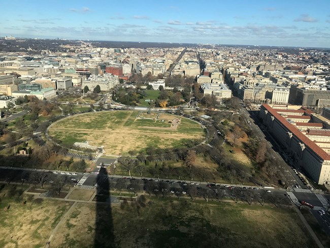 Ellipse from Washington Monument Aerial view of the Ellipse, a circular area of turf, and surrounding park and city. The narrow shadow of the Washington Monument is in the foreground and the White House is in the center.