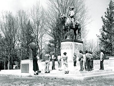 Visitors stand in front of the Nathanael Greene Statue, a man atop a horse on top of a monument base