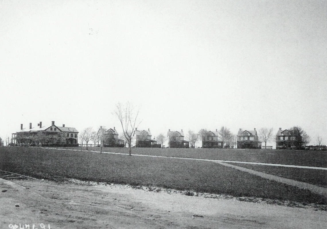 FOWA_military-quarters-historic A uniform row of two-story houses lines the edge of a flat, open field