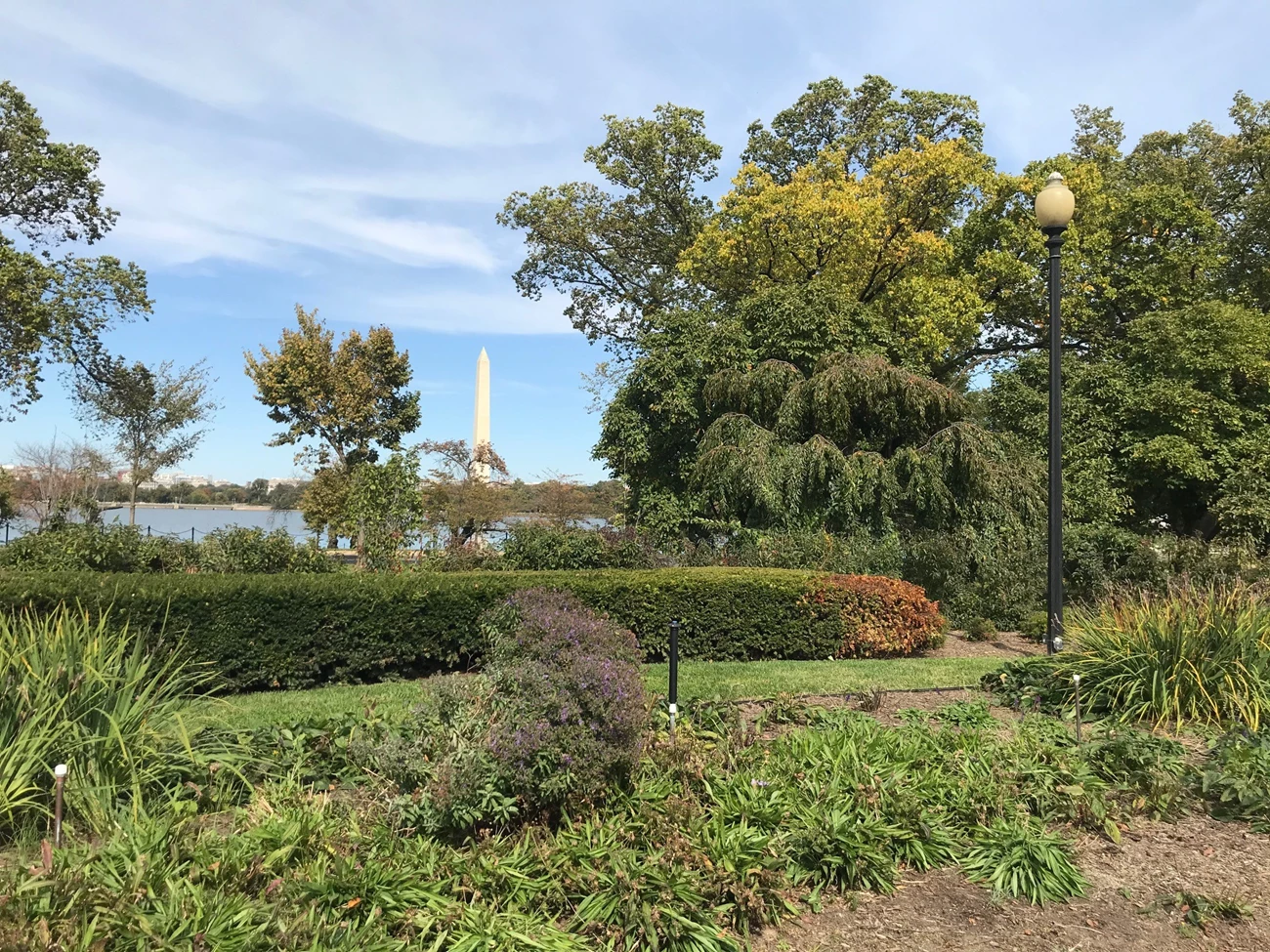 View toward Washington Monument Flower beds, a low hedge, a trees of the George Mason Memorial with the Tidal Basin and Washington Monument in the background.