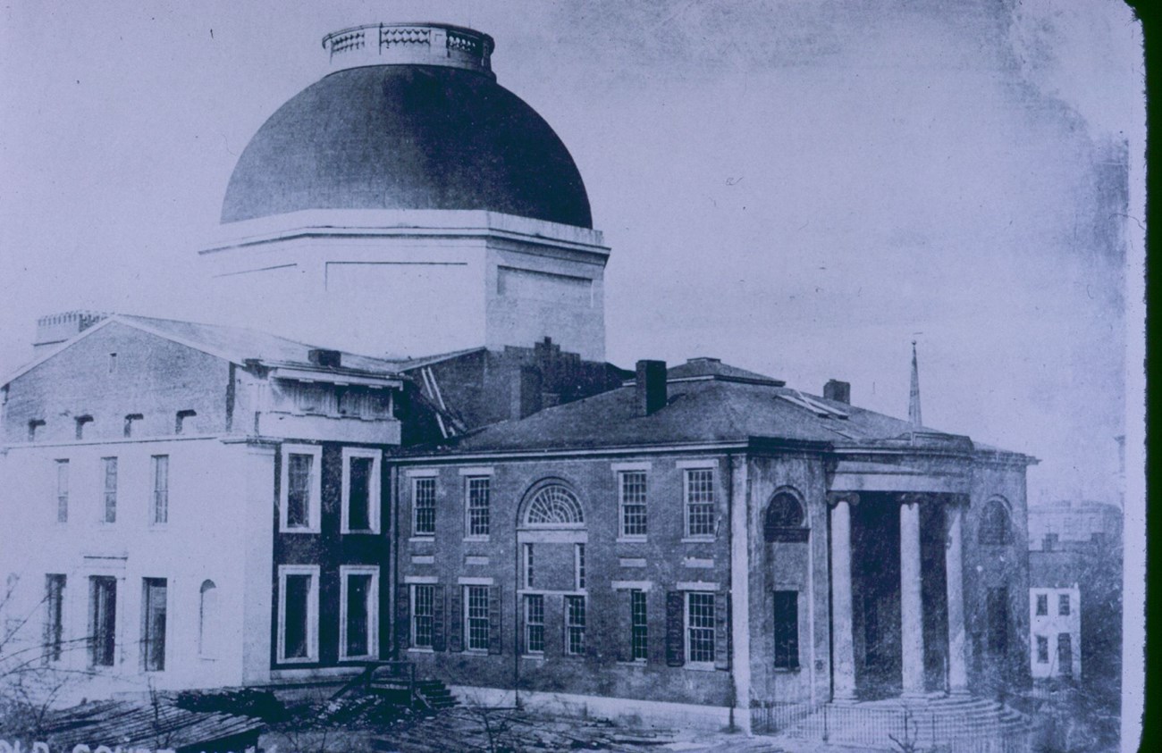 JEFF_Old-Courthouse-1850sCompressed Scene at the Old Courthouse square in 1851 (photograph), with a wide dome on the Greek Revival style building