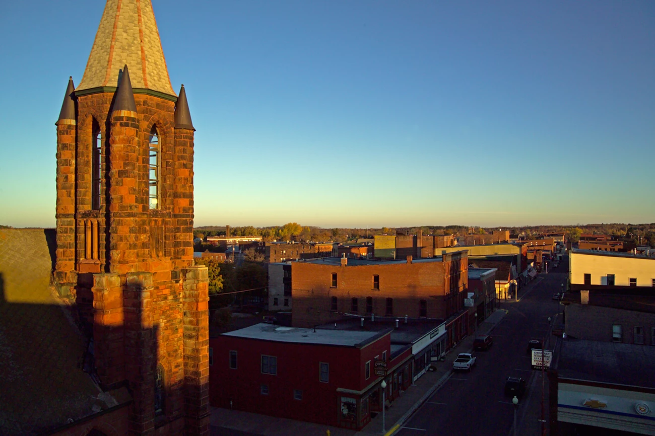 View of Calumet from the Union Building Morning light illuminates the stones of the steeple of St. Anne's and Calumet's commercial district of low brick buildings.