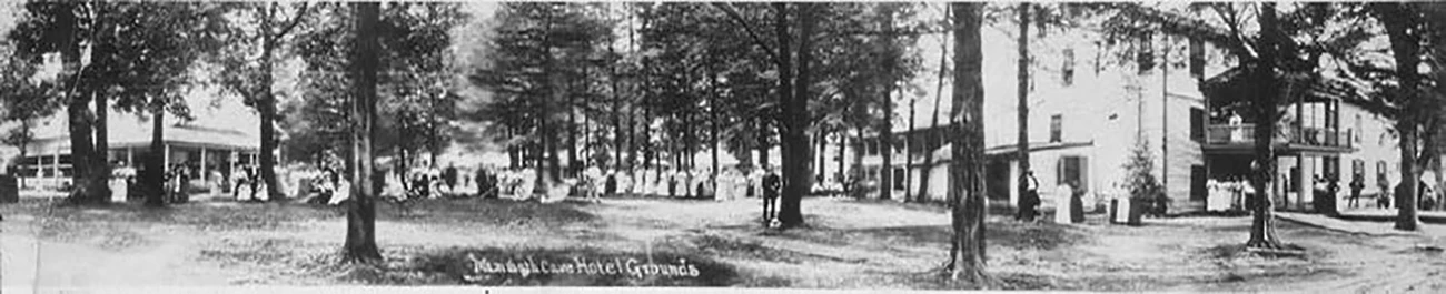 Mammoth Cave Hotel, ca. 1915 Black and white panorama of Mammoth Cave Hotel Grounds with people posed in the lawn, under scattered trees, and on the porch of the two-story hotel
