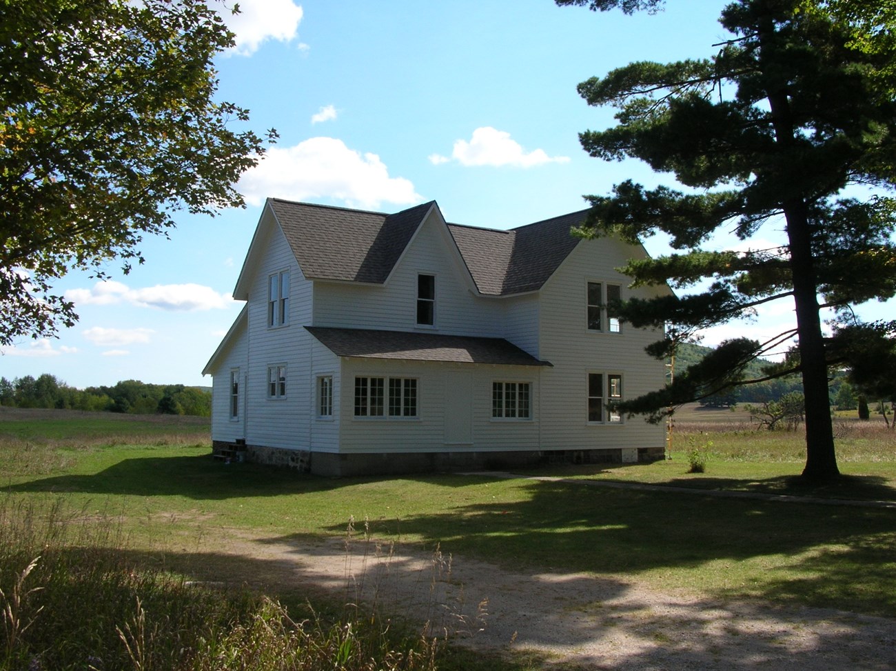 SLBE-Port-Oneida-Kelderhouse Two story farmhouse in fall in an open rural landscape at Port Oneida