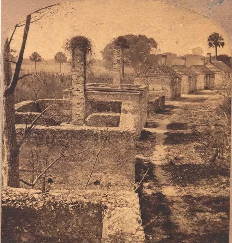 Tabby Slave Cabins at Kingsley Plantation Historic image of a row of two-room cabins in an arc formation, some without roofs and with bird nests atop the chimney.