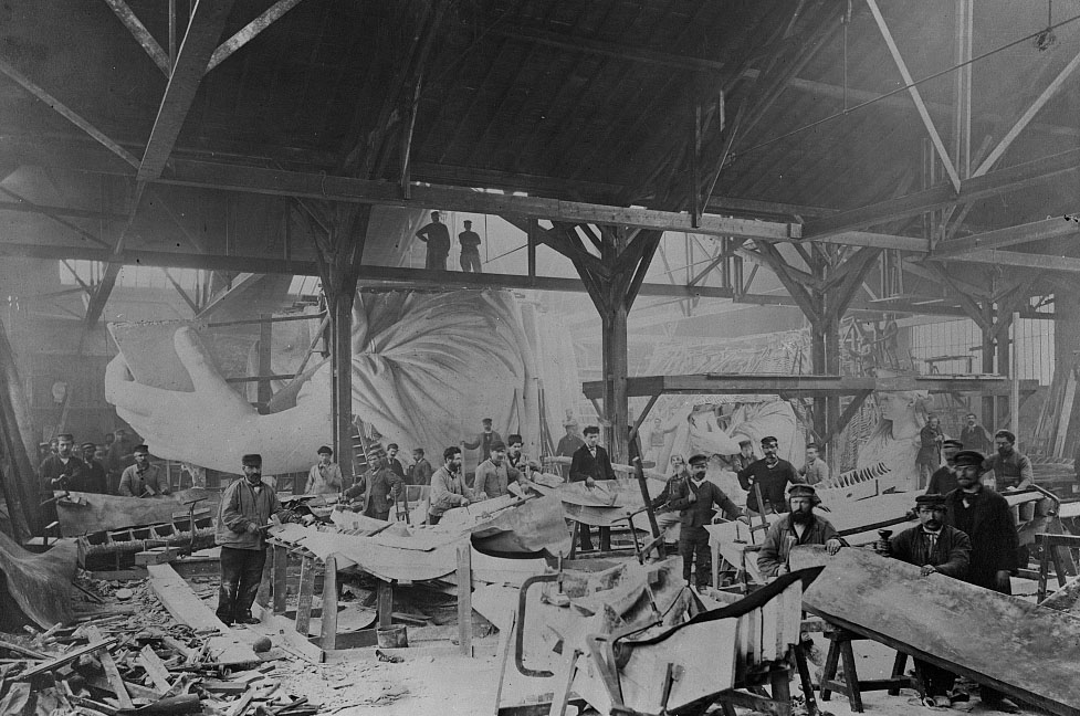 Workmen constructing the Statue of Liberty, hammering copper, with left hand and head of the statue in background, at the Gaget, Gauthier & Co. workshop in Paris (1881-1883)