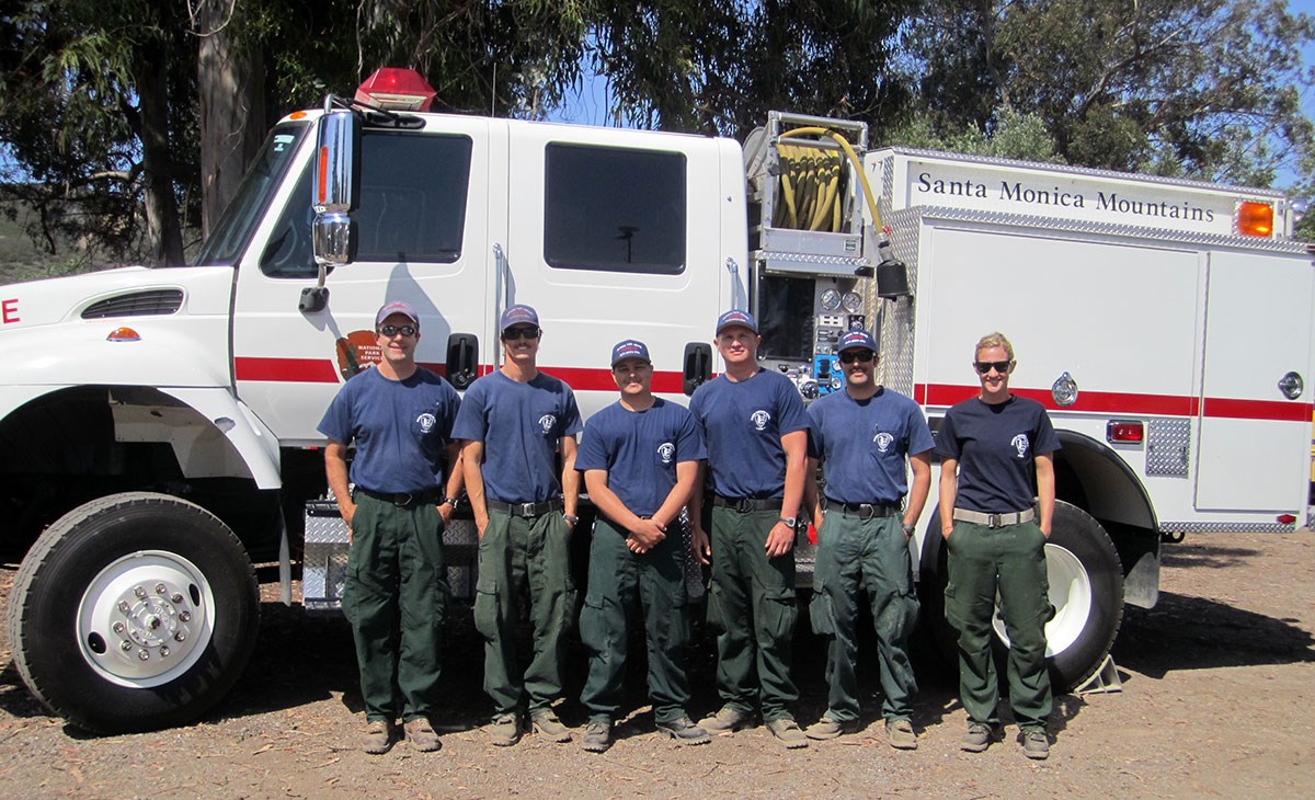 lt= Engine 73 crew in front of a wildland fire engine.