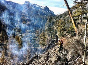 A firefighter hikes in to the confluence of Spruce and Forest Canyons, through steep rocky terrain on November 30.