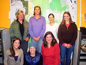 A group poses for the camera in a small room.