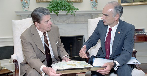 President Reagan holds a map of Yellowstone while looking at Secretary Hodel to his right