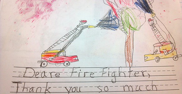 A drawing of firefighters in engines extinguishing a tree. Text below reads: Deare [sic] Fire Fighter, Thank you so much.