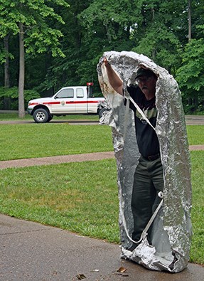 A firefighter with a fire shelter around him.