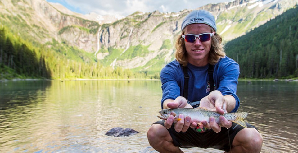 Fisherman posing with fish for photo.