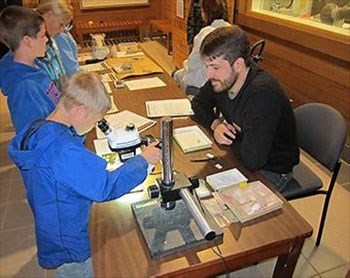 Children viewing fossils on a display table.