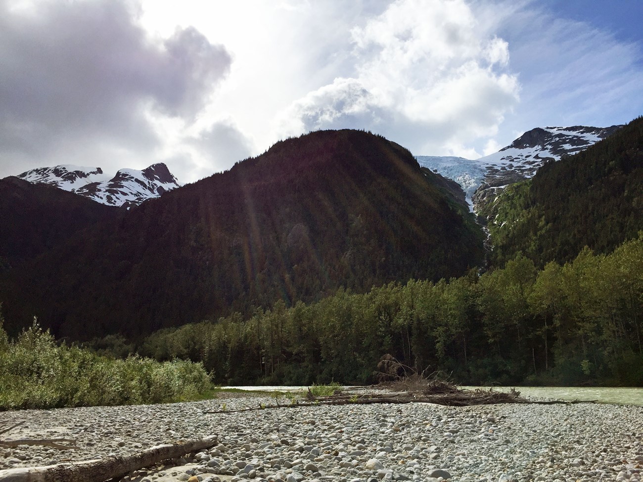 KLGO SEAN Irene Glacier in the distance, small stream and rocky shore in the foreground.