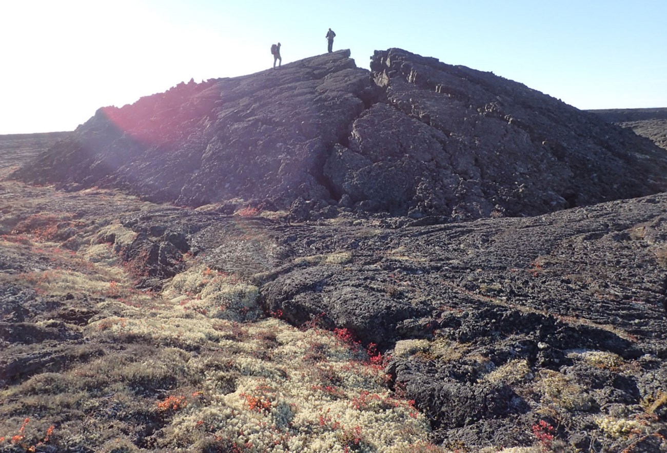 photo of two people standing atop lava dome