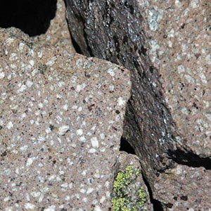 Photo of light-colored boulders with large black and white crystals.