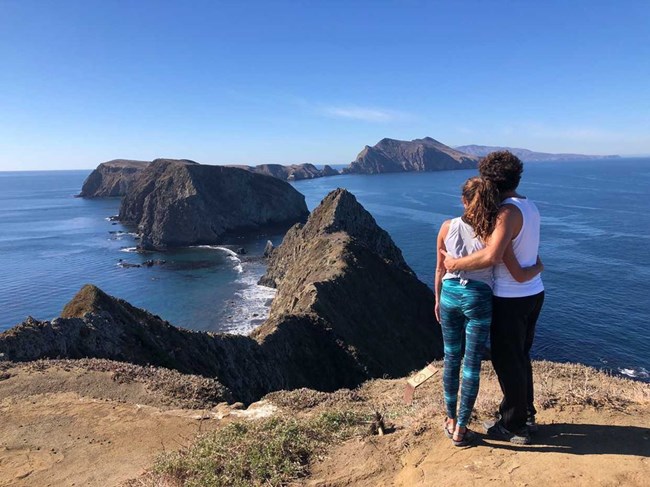 Couple looking out to an ocean view with islands in the distance.