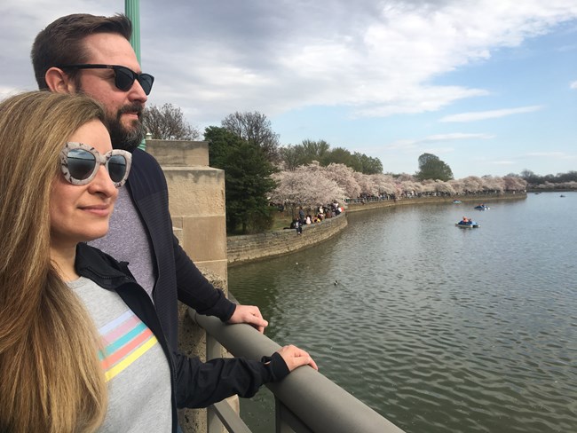 Two people in sunglasses looking at the Tidal Basin