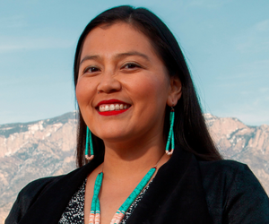Learn more about panelist, Jaclyn Roessel. person poses for a picture with mountains in the background