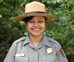 Vanessa Torres park ranger poses for picture in front of nature background