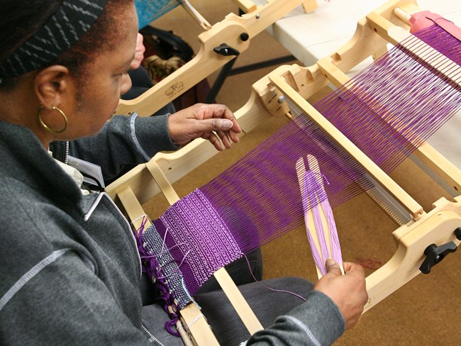 A woman works on a small loom at the John C. Campbell Folk School