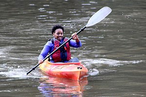 A girl kayaks in a river.