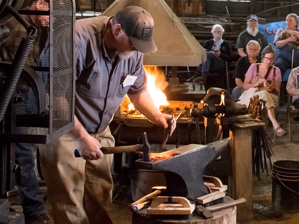 Blacksmith pounding red-hot metal at Hammer-In Festival