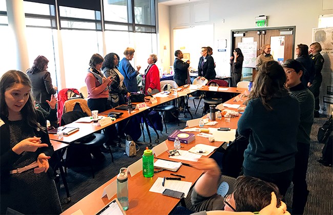 Participants of 19th Amendment Workshop Converse Around Large Table
