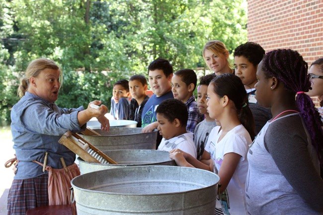A group of schoolchildren learn how people did laundry—with tubs and washboards—in the 1800s at the National Canal Museum