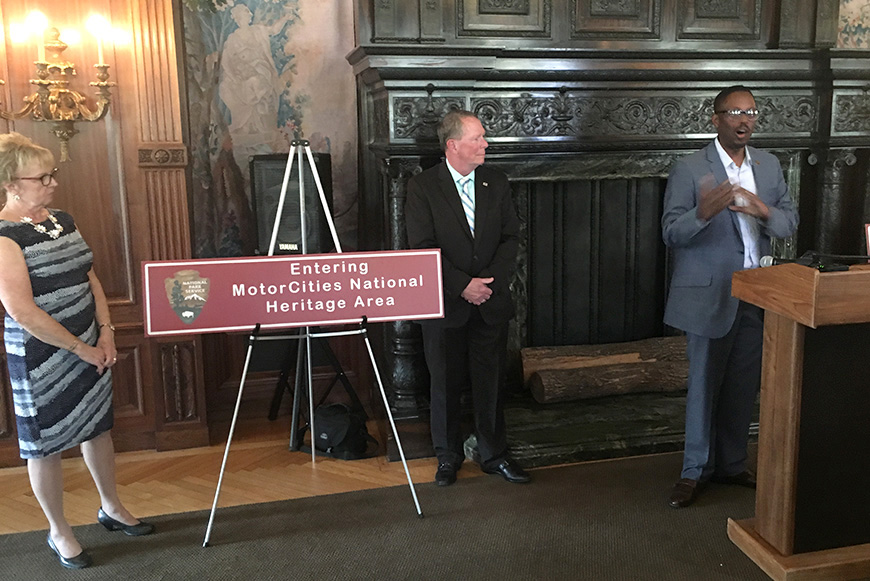 MotorCities NHA staff and board members next to a brown highway sign at Fair Lane in Dearborn, MI