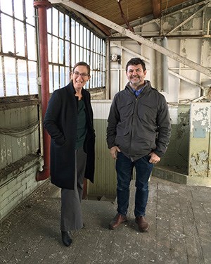 A woman and a man standing in an old warehouse