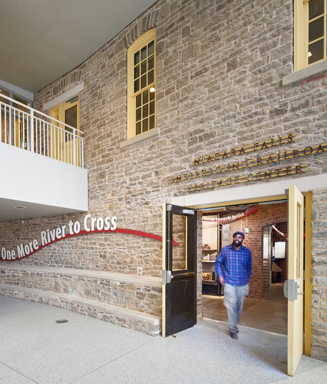 A visitor walks through the entrance of the ‘One More River to Cross’ exhibit of the Niagara Falls Underground Railroad Heritage Center