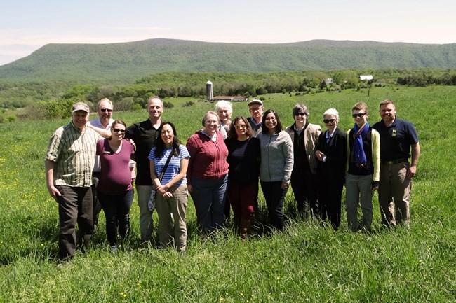 NHA Program Staff stand in the grass on Fisher’s Hill in the Shenandoah Valley