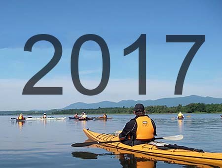 Text: "2017" over people kayaking on a river. Text: "2017" over people kayaking on a river.