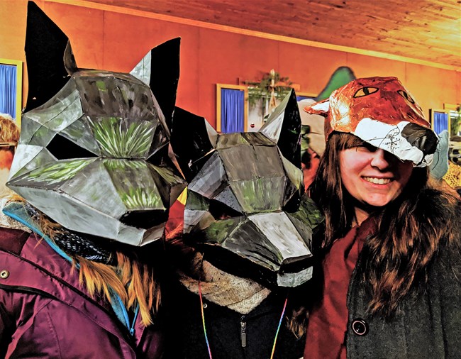 Three people in wolf masks and a fox mask.