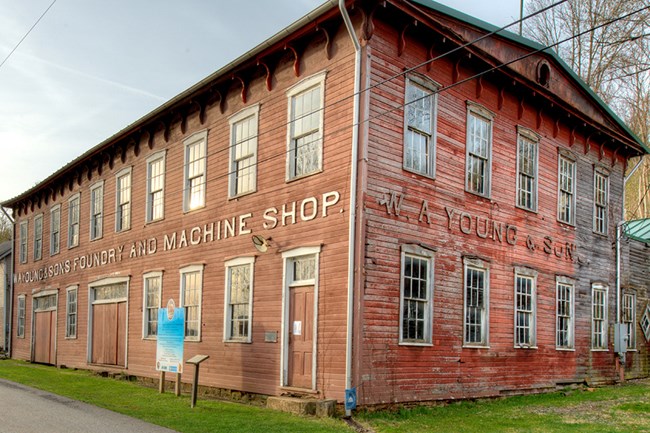 lt= Exterior of W.A. Young & Sons Foundry and Machine Shop, an old wooden building in Rices Landing, PA