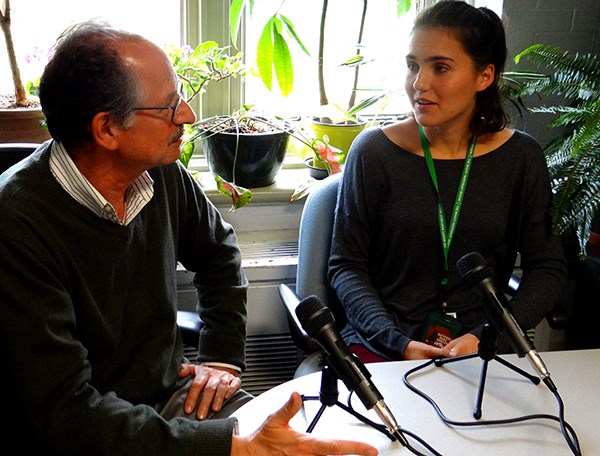Two podcast hosts speak into microphones. Two podcast hosts speak into microphones.