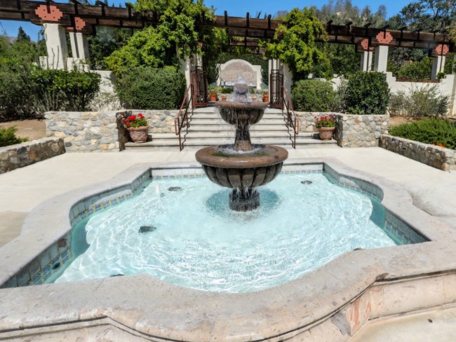 Stone fountain in front of terrace and gravestone