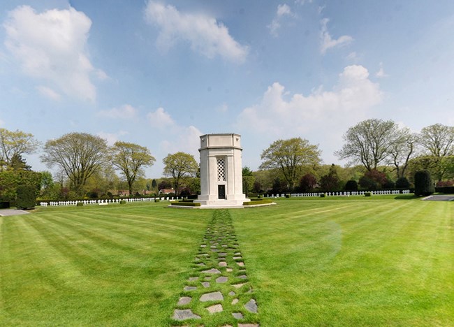 Image of white monument on a green lawn with stone pathways