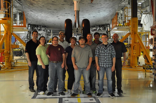 Photo of ten people standing in front of shuttle gear