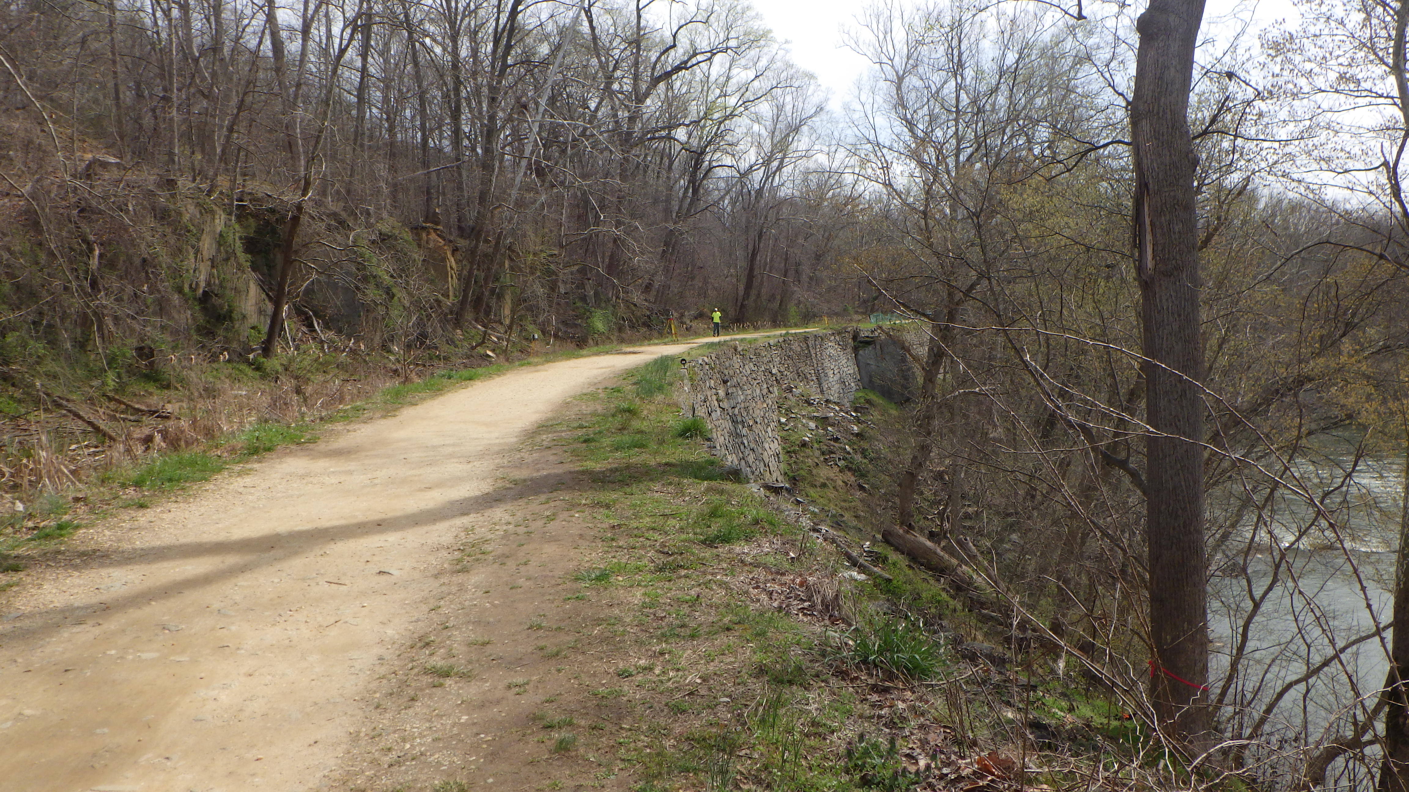 Photograph of path on top of stone retaining wall with person in distance