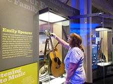 A woman checks the temperature inside an exhibit case